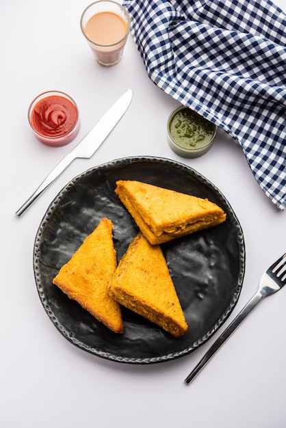 Sandwich Bread Pakora or triangle shape pakoda served with tomato ketchup, green chutney, Popular indian tea-time snack