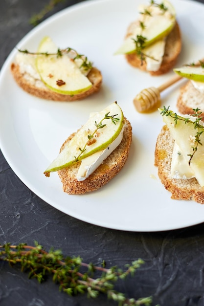 Sandwich or bruschetta with pear and blue cheese on white plate