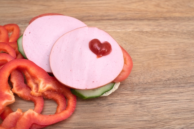 Sandwich  and chopped peppers on wooden table