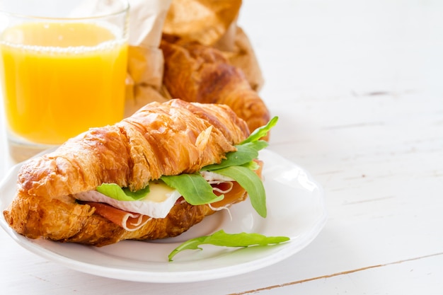 Sandwich croissant with ham brie arugula