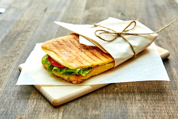 Sandwich in an envelope, tied with rope to a wooden table
