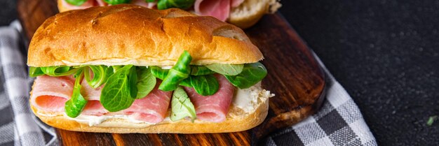 сэндвич французские булочки с молоком ветчина, сыр, листья салата зеленые листья биопродукт свежая здоровая еда еда
