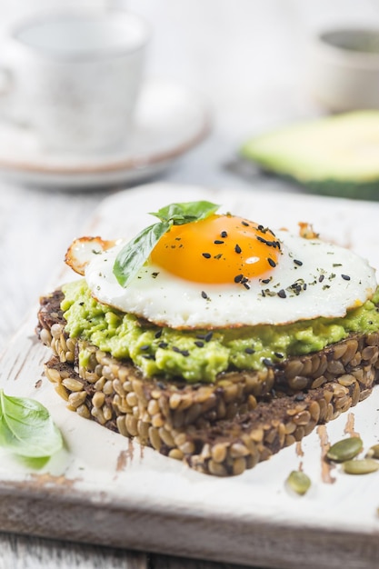 Sandwich met avocado-ei en spinazie op een wit houten achtergrond gezond dieetontbijt