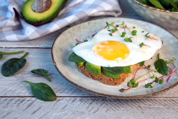 Sandwich met avocado-ei spinazie microgreens en sesam Gezond voedsel rijk aan vezels gezonde vetten vitamines sporenelementen