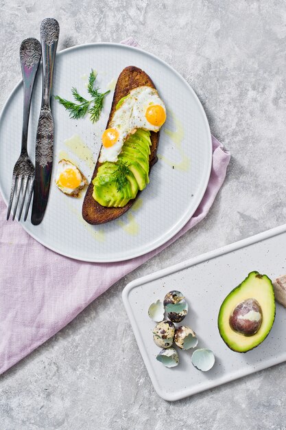 Sandwich met avocado en ei op toast van zwart brood.