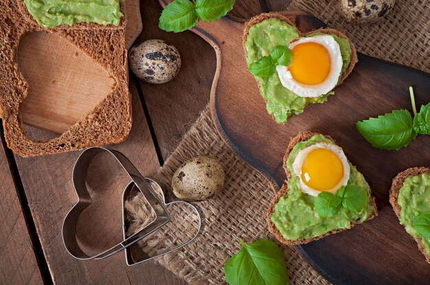 Sandwich met avocadopasta en ei in de vorm van een hart