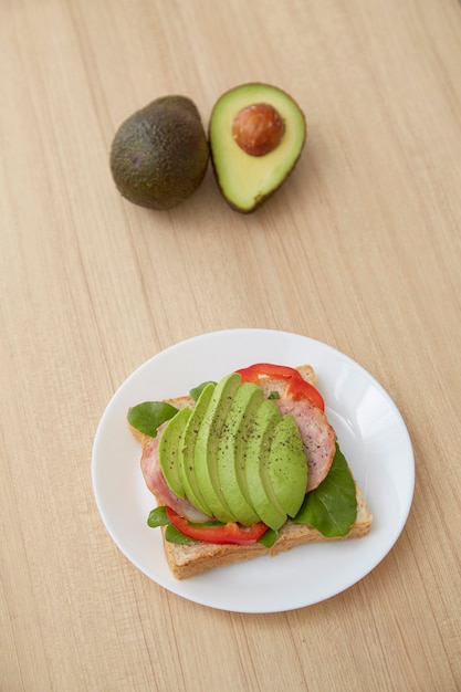 Sandwich met avocadoplakken en bacon