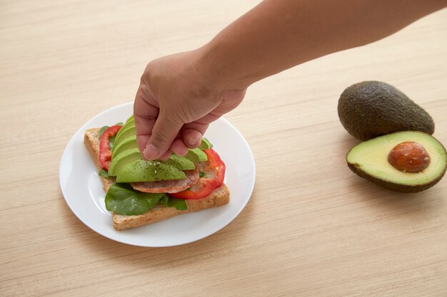 Sandwich met avocadoplakken en bacon