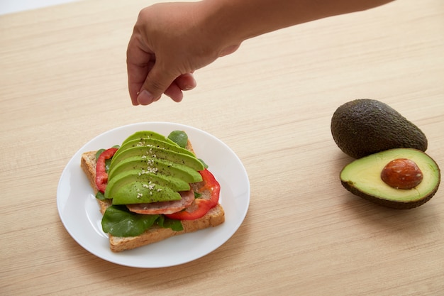 Sandwich met avocadoplakken en bacon