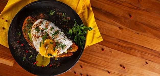 Sandwich met een plakje Italiaanse brood avocado en gebakken ei met vloeiend eigeel