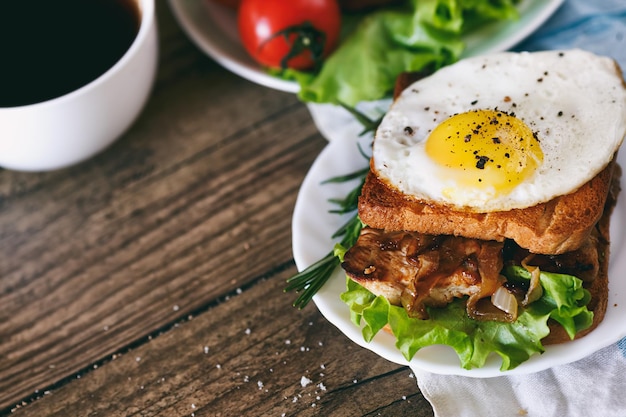 Sandwich met eieren, kip, komkommer en sla op een houten achtergrond Selectieve focus kopieerruimte