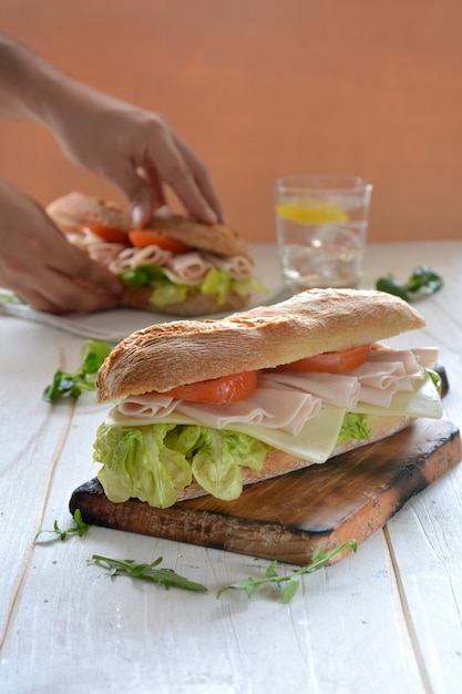 Sandwich met kaas en kalkoenham geserveerd met sla en tomaat