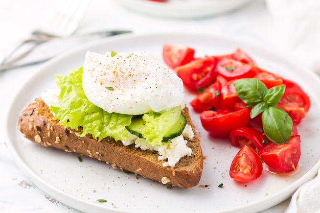 Sandwich met kaasroom, salade en gepocheerd ei.