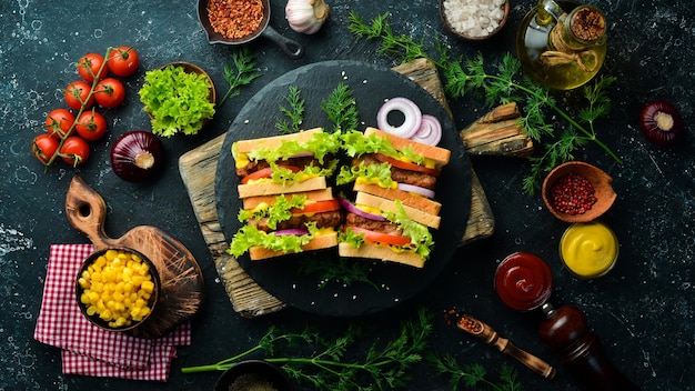 Sandwich met koteletkaas en sla op een zwarte stenen achtergrond Straatvoedsel Bovenaanzicht Gratis kopieerruimte