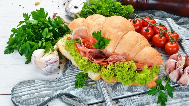 Sandwich met plakjes Prosciutto op oude houten achtergrond Croissant Ontbijt Bovenaanzicht Vrije ruimte voor uw tekst