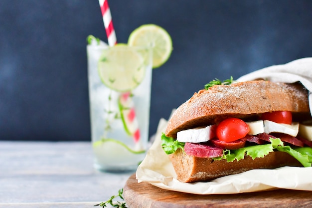 sandwich met salami en kaas op een houten bord