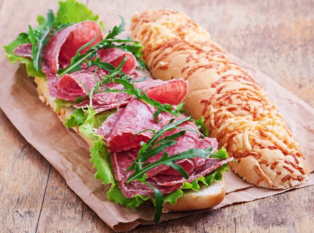 Sandwich met salami, sla, tomaat en rucola