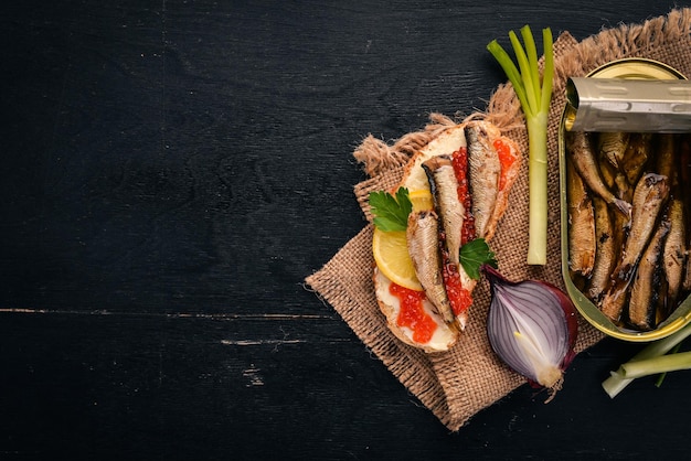 Sandwich met sprot en kaviaar-ui op een houten ondergrond Bovenaanzicht Kopieer de ruimte