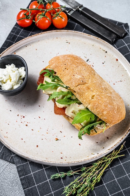 Sandwich met verse camembert, perenmarmelade, ricotta en rucola. grijze achtergrond. bovenaanzicht