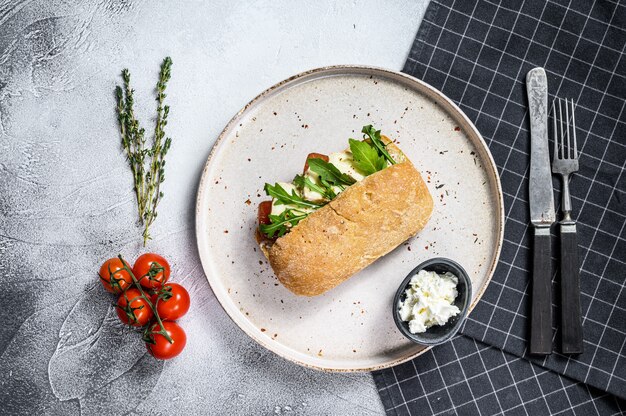 Sandwich met verse camembertkaas, perenmarmelade, ricotta en rucola. Bovenaanzicht