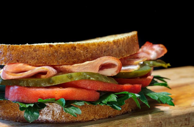 Sandwich met vlees en groenten close-up op een zwarte achtergrond