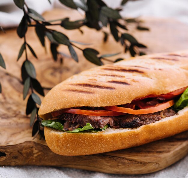 Sandwich met vlees en groenten op een houten plank