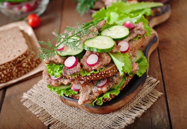 Sandwich met vlees, groenten en sneetjes roggebrood