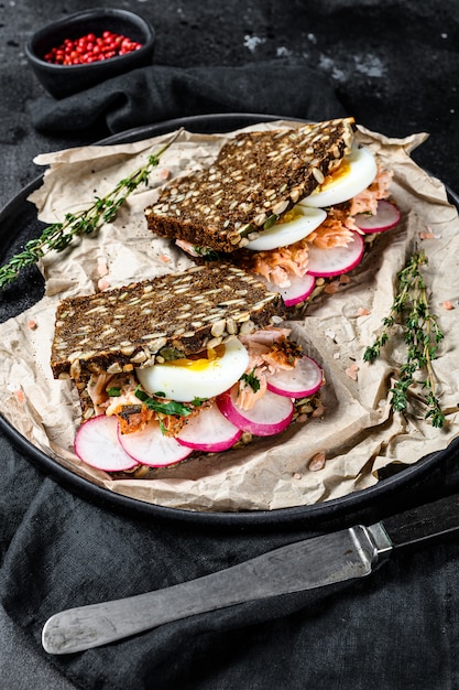 Sandwich met warm gerookte zalm en graanbrood.