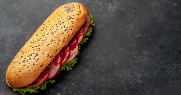 sandwich met worst, kaas en salade op een stenen achtergrond. met kopie ruimte voor uw tekst