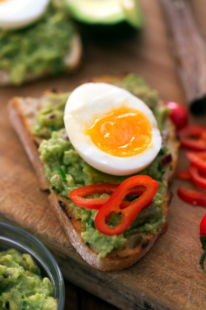 Sandwich prepared with guacamole, pepper and boiled chicken egg