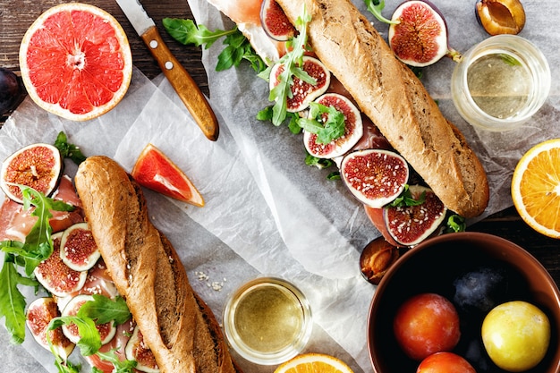 Foto copyspace di vista superiore del vino dei fichi del formaggio di mascarpone del prosciutto di parma del panino