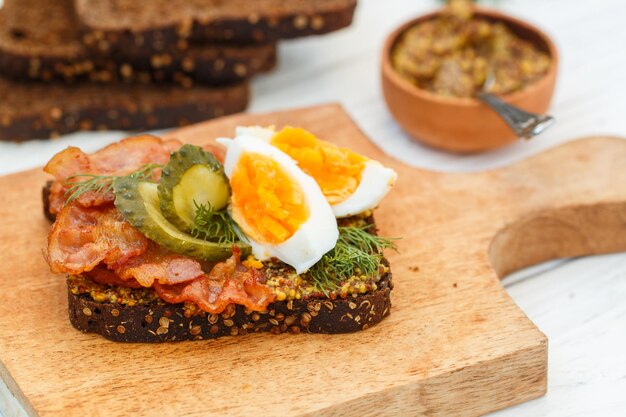 Panino di pane di segale al coriandolo con pancetta fritta