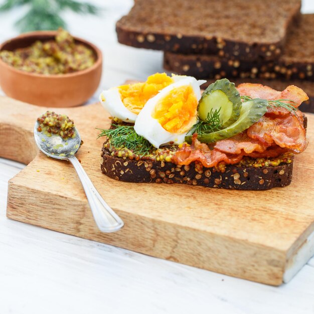 sandwich of rye bread with coriander with fried bacon