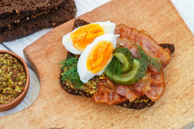 sandwich of rye bread with coriander with fried bacon