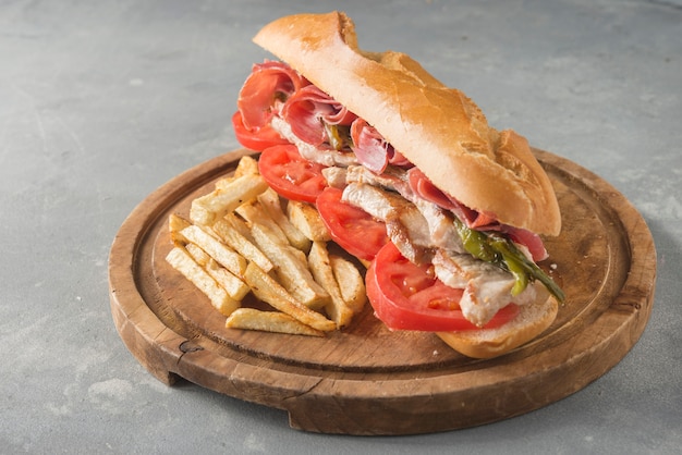 Photo sandwich serranito typical in andalusia with ham, gren pepper and grilled pork loin