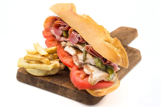 Sandwich Serranito typical in Andalusia with ham, gren pepper and grilled pork loin