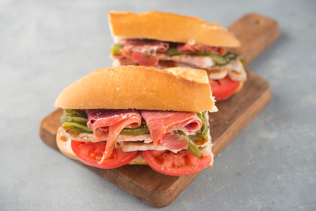 Foto panino serranito tipico dell'andalusia con prosciutto, pepe verde e lonza di maiale alla griglia