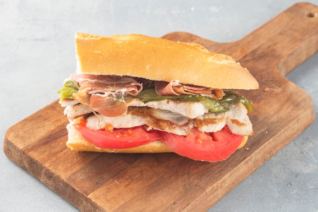 Sandwich Serranito typical in Andalusia with ham gren pepper and grilled pork loin