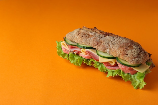 Sandwich van ciabattabrood op oranje achtergrond