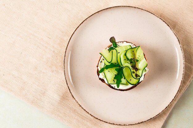 Sandwich white bread with cream cheese and sliced cucumber breakfast top view no people on a beige table