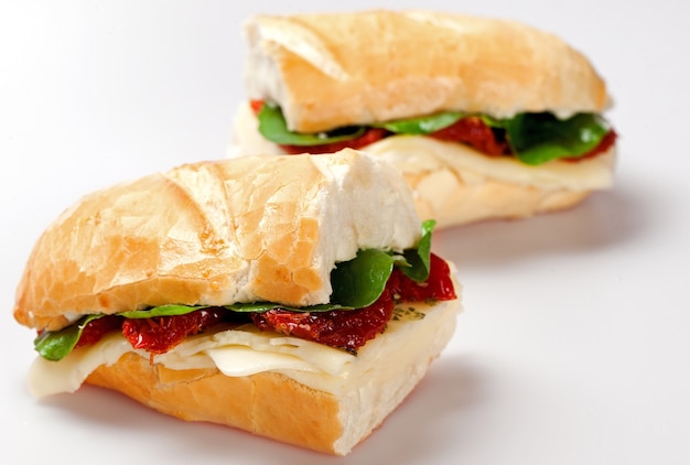 七面鳥の胸肉、トマト、レタス、チーズをテーブルに置いた白いプレートのサンドイッチ
