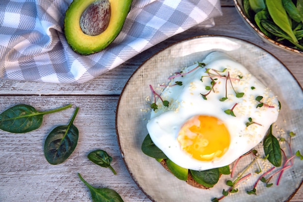 Photo sandwich with avocado egg spinach microgreens and sesame healthy food rich in fiber healthy fats vitamins trace elements