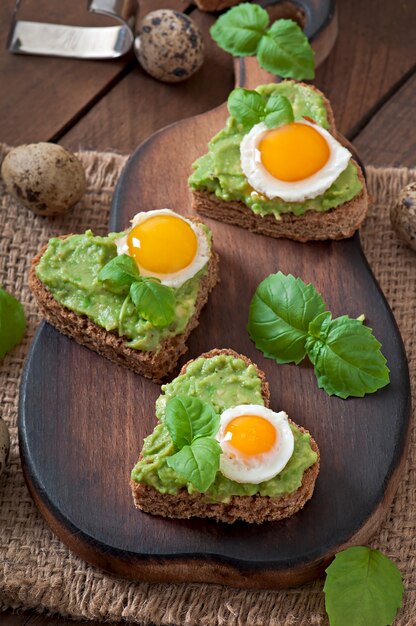 Sandwich with avocado paste and egg in the shape of heart