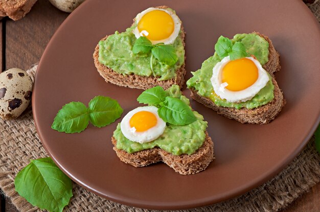 Sandwich with avocado paste and egg in the shape of heart