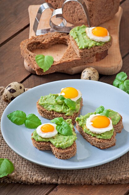 Sandwich with avocado paste and egg in the shape of heart