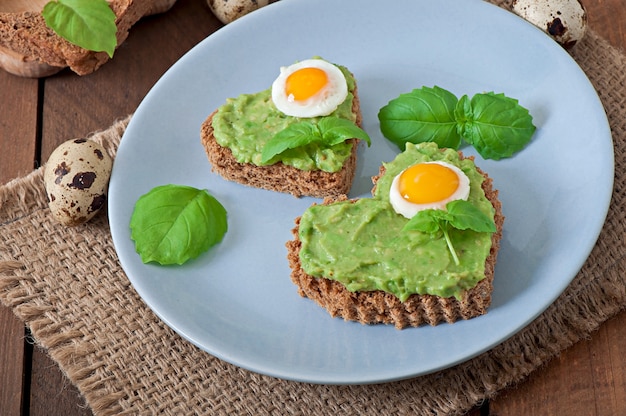 Sandwich with avocado paste and egg in the shape of heart