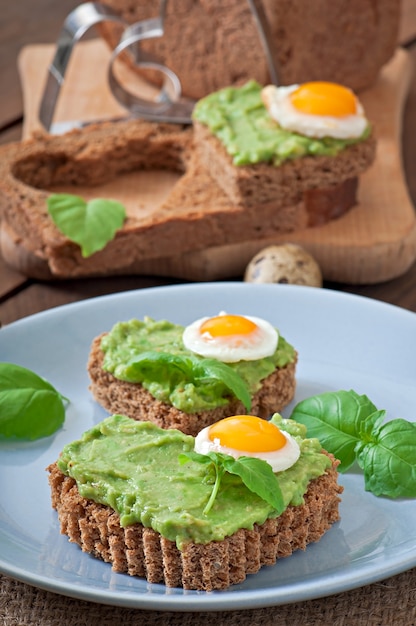 Sandwich with avocado paste and egg in the shape of heart