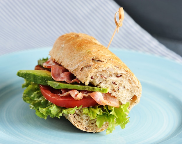 Sandwich with bacon and avocado pierced with a skewer