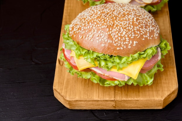 Sandwich with bacon and cheese on a wooden board