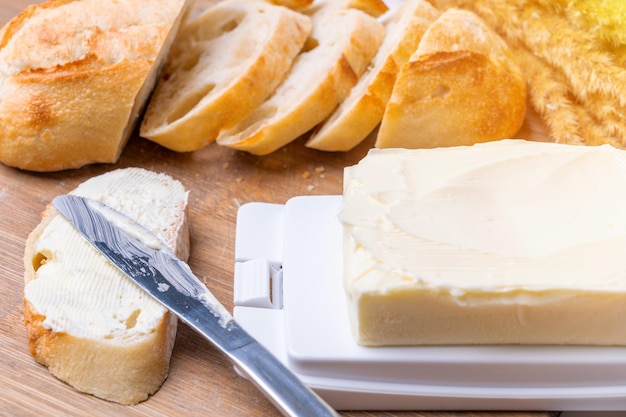 Sandwich with butter on a cutting board butter dish with butter and a table knife